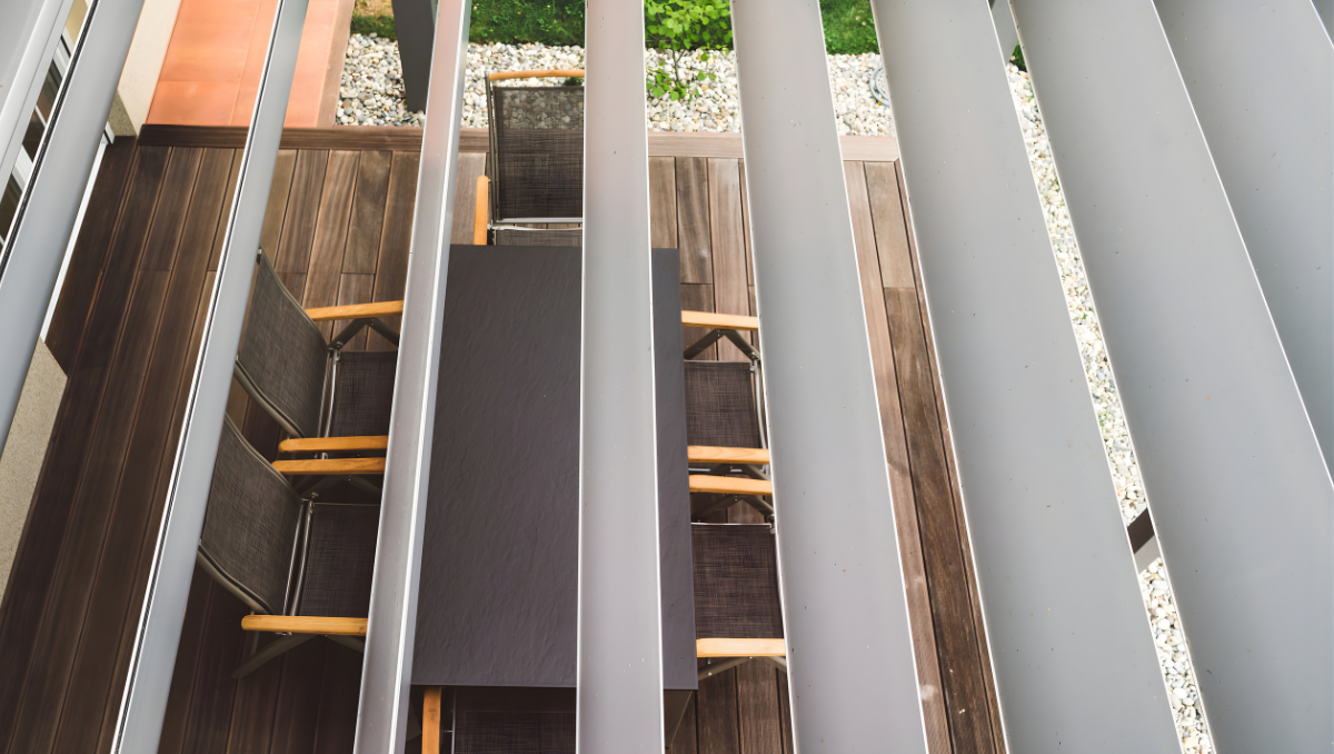 Motorized louvered pergola with adjustable aluminum roof over outdoor dining area