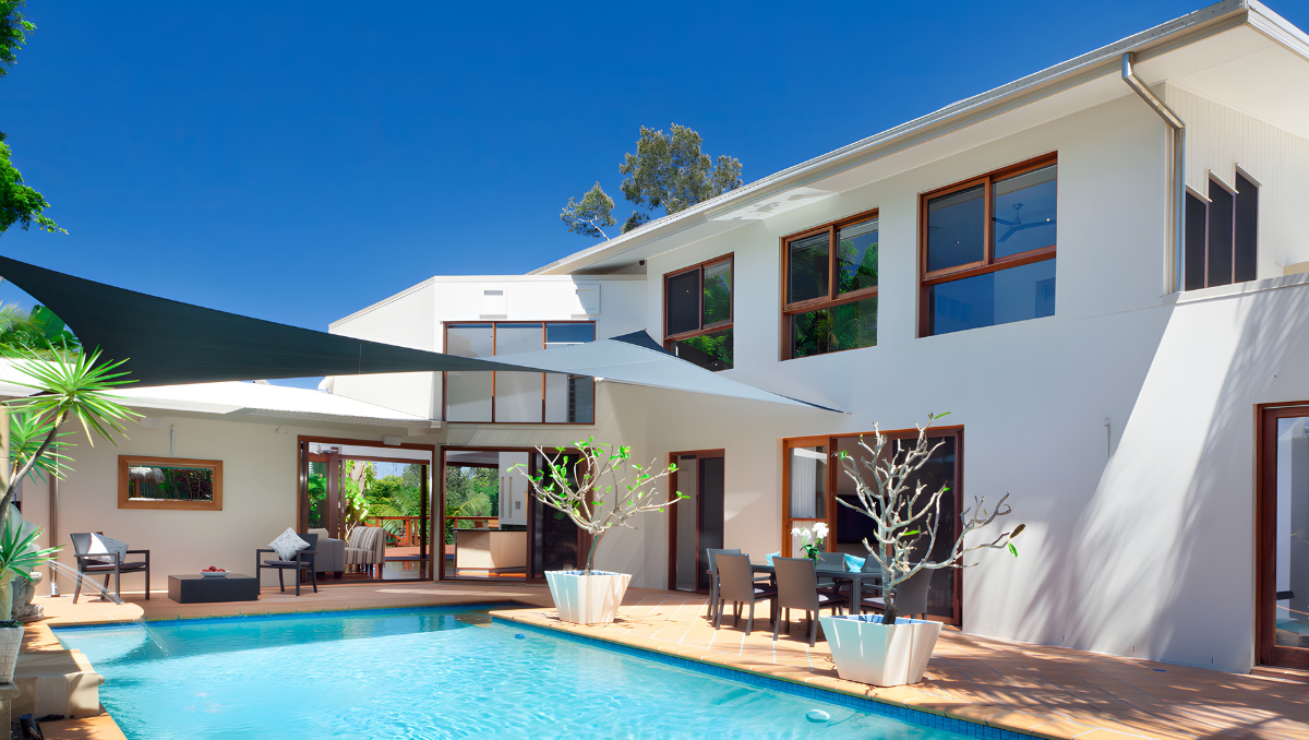 Shade sail patio structure providing poolside shade at a modern coastal home in Delaware, creating a comfortable outdoor living space.