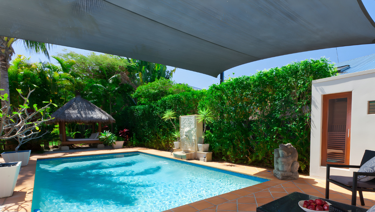 Residential pool area covered with shade sail canopy creating a cool and comfortable outdoor living space