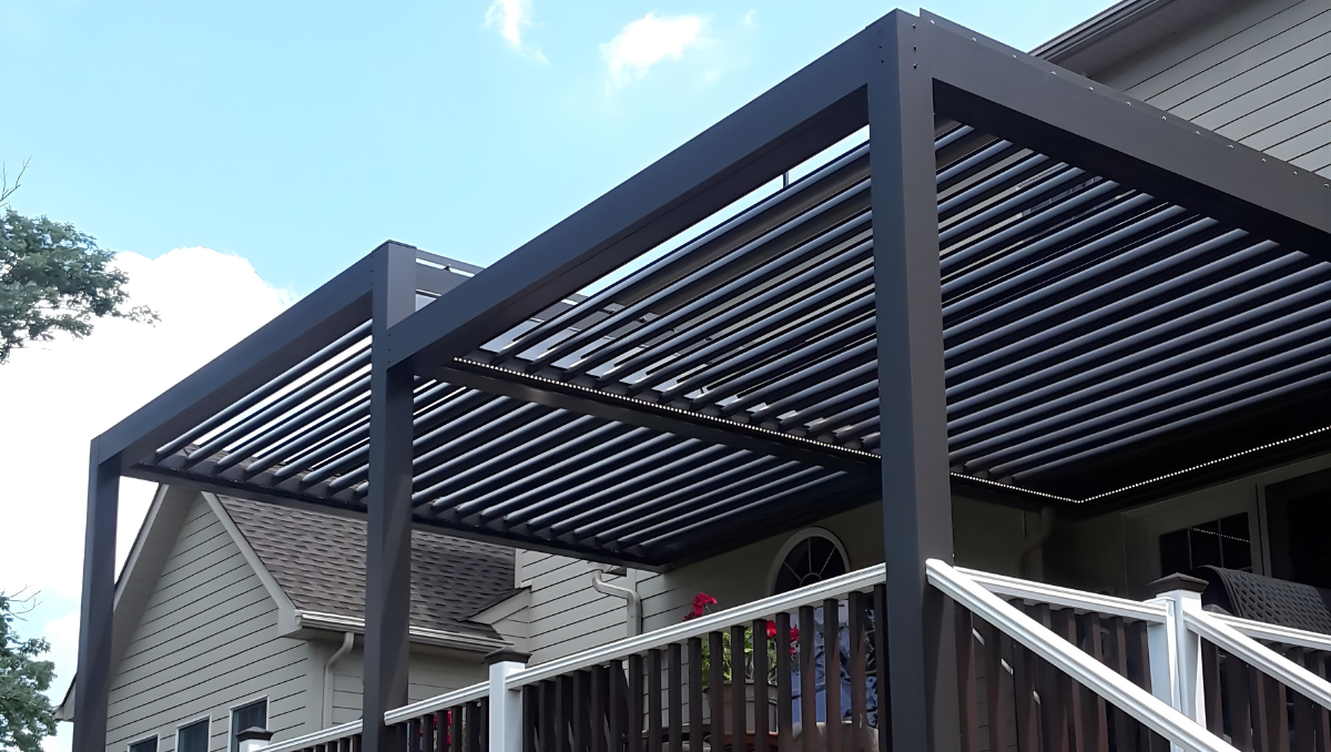 Modern black aluminum pergola installed over raised deck with adjustable roof louvers at residential home
