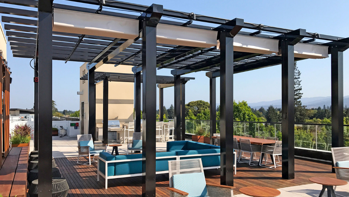 Modern rooftop hospitality space with commercial retractable canopy and outdoor lounge seating