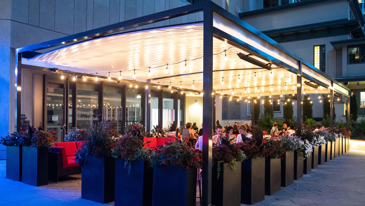 Commercial Retractable Canopy for Outdoor Restaurant Dining Commercial retractable canopy covering outdoor restaurant dining area with lighting and seating