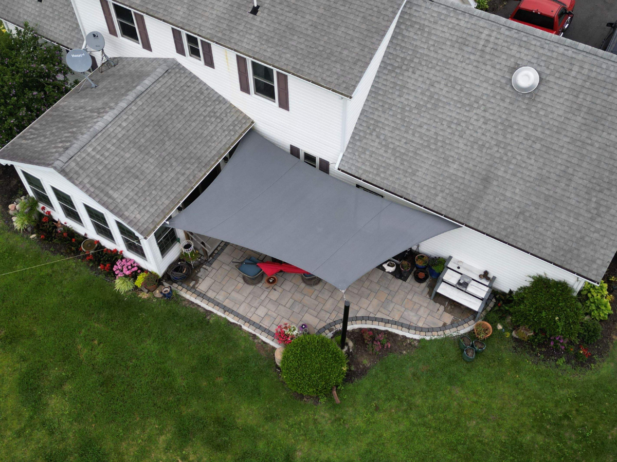 Aerial view of a custom shade sail installation over a backyard patio in Bridgeville, Delaware.