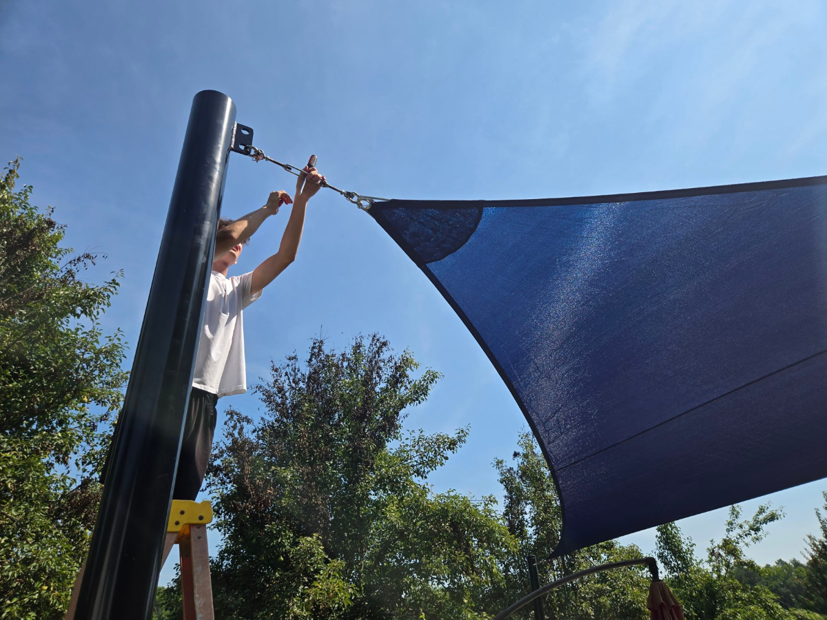 Shade Sail Systems installer tensioning a custom shade sail during installation in Princess Anne,MD.