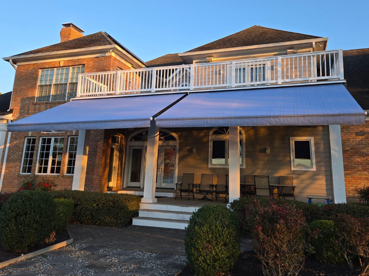 Motorized retractable awnings extending over a residential patio to provide comfortable outdoor shade.