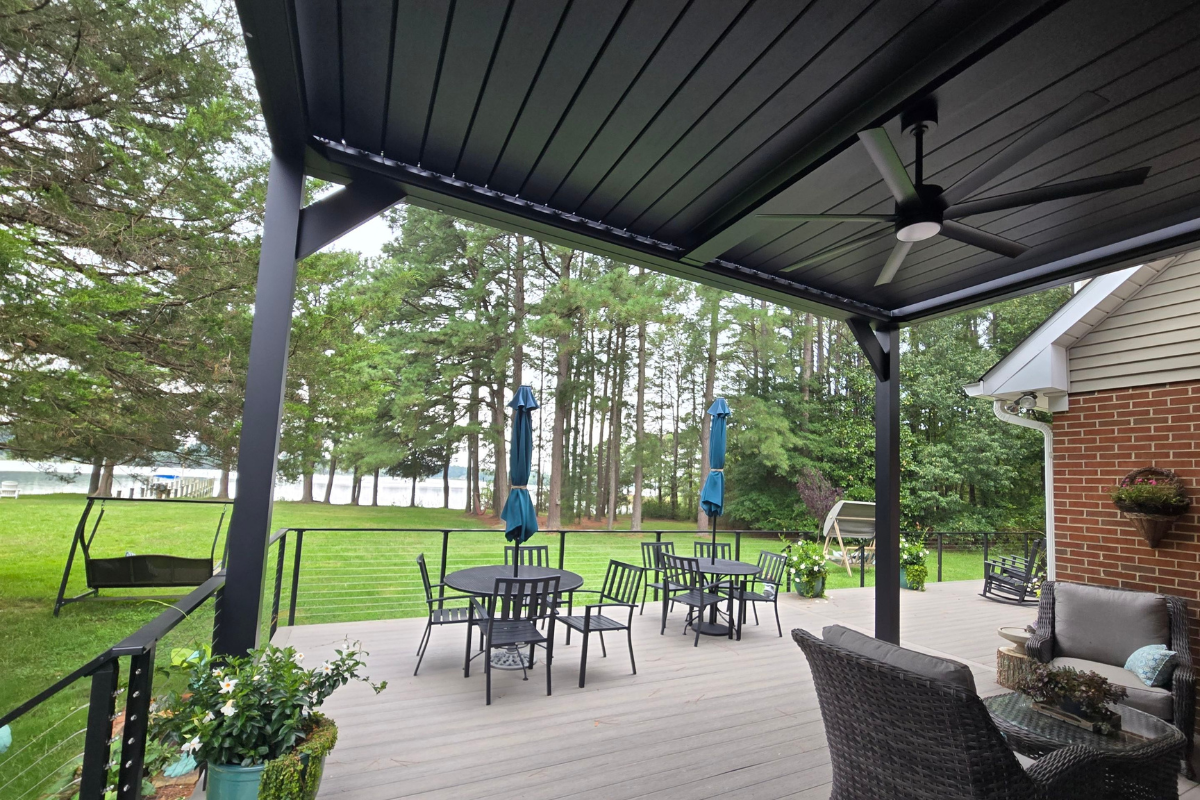 Custom Pergola Outdoor Living Space Covered outdoor living space beneath a motorized louvered pergola overlooking the water